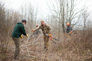 Volunteers build brush piles